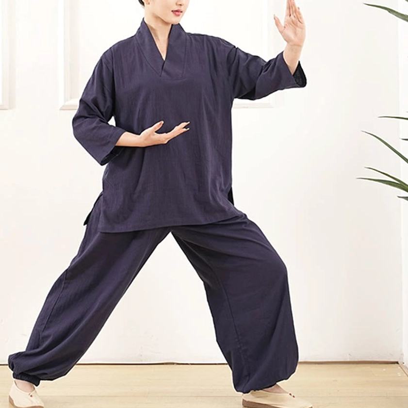 Side view of women in navy blue loose cotton tai chi practice clothing in dynamic movement