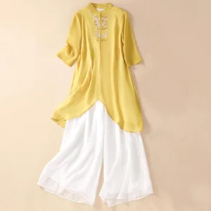 Women's Zen meditation embroidered two-piece set featuring yellow tunic with floral embroidery and white wide leg pants, front flat lay view