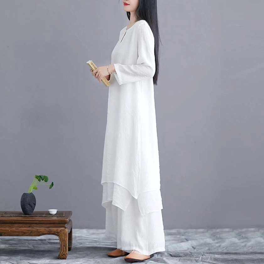 Close-up right side view of white zen clothing set with model holding spiritual book