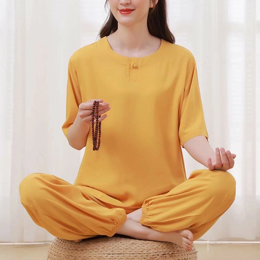 Women's yellow zen meditation tai chi clothing set, three-quarter side seated view showing crew neck and half sleeve with prayer beads