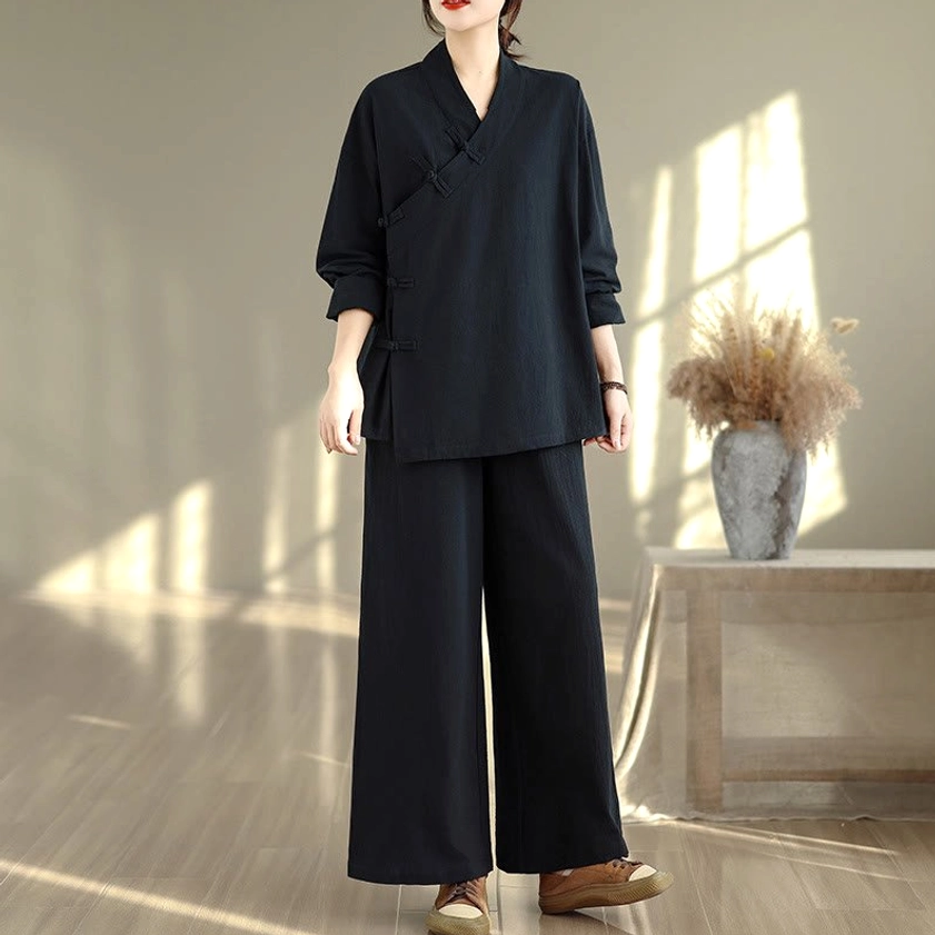 Women's zen meditation yoga uniform in all-black, full body front view showing v-neck long sleeve top and wide-leg pants