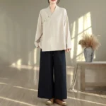 Women's beige zen meditation yoga uniform set with black wide-leg pants, full body front view showcasing v-neck long sleeve top