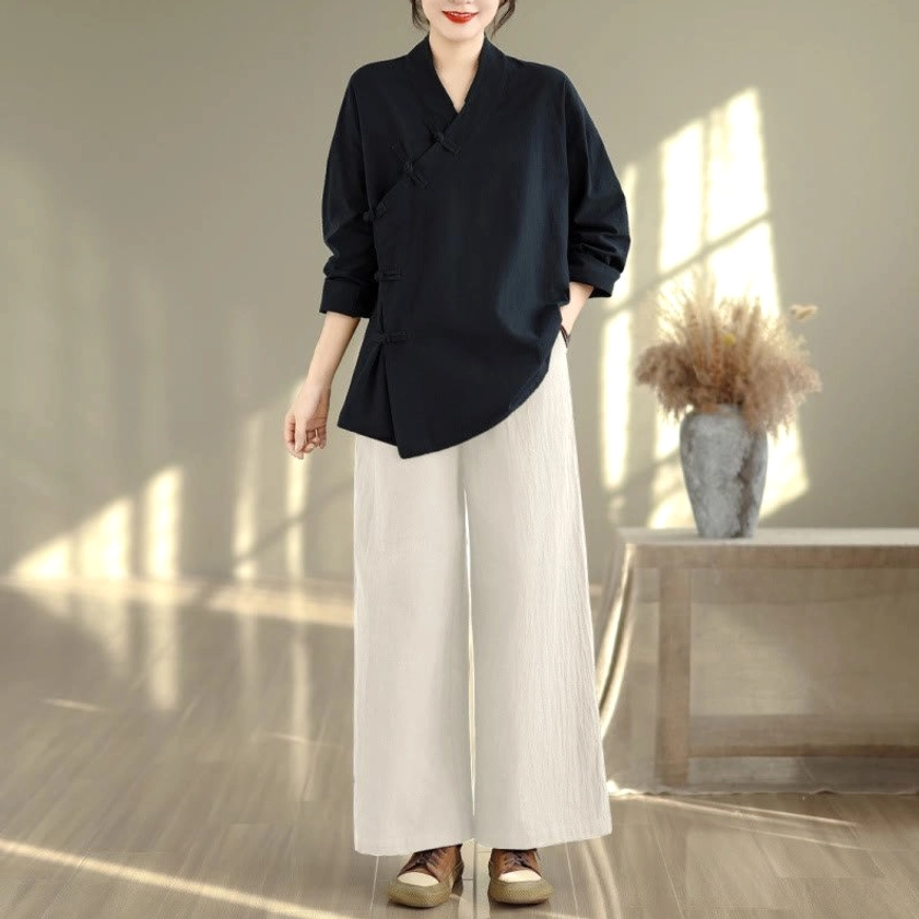 Women's zen meditation yoga uniform set with black top and beige wide-leg pants, full body front view