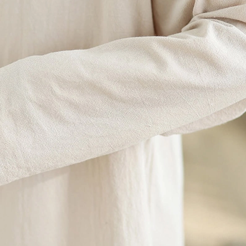 Women's zen meditation yoga uniform full body shot showing beige shirt and black wide-leg pants in studio lighting