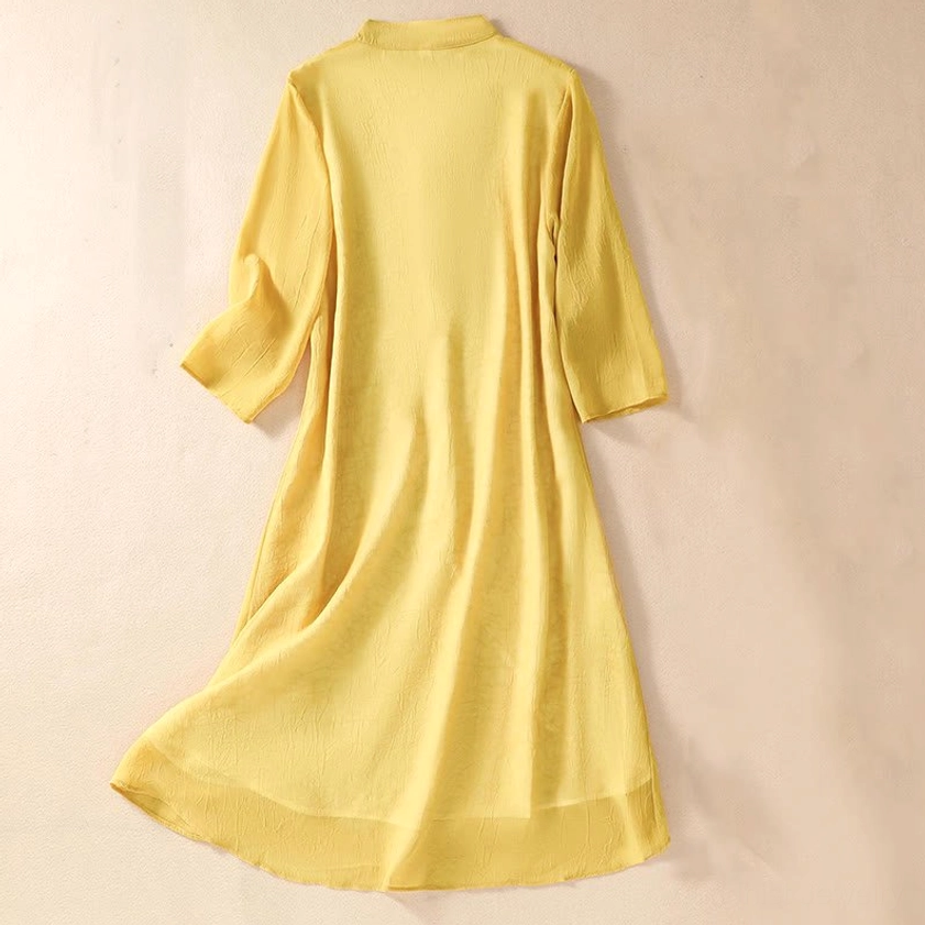 Back view of yellow embroidered meditation tunic showing asymmetrical hemline, three-quarter sleeves, and traditional stand collar design