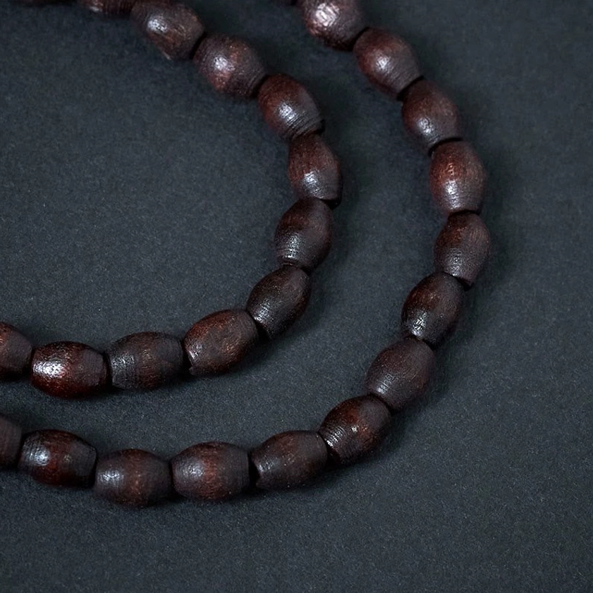 Single-strand wooden bead mala necklace close-up showing smooth natural brown beads and craftsmanship