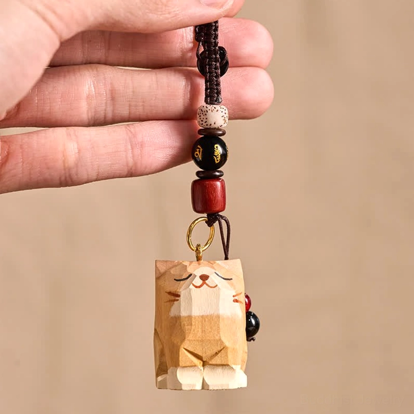 Hand-held wooden cat Om Mani Padme Hum keychain showing size reference with gold metal jump ring hardware