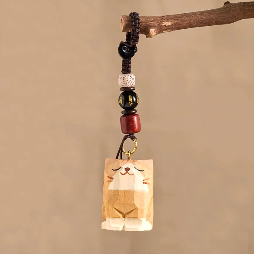Minimalist wooden cat Om Mani Padme Hum keychain hanging from wooden twig showing spiritual carving detail