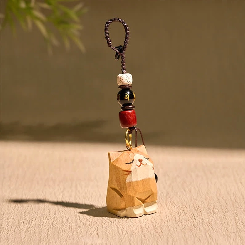 Buddhist wooden cat keychain side view with braided rope lanyard showcasing natural wood texture and grain