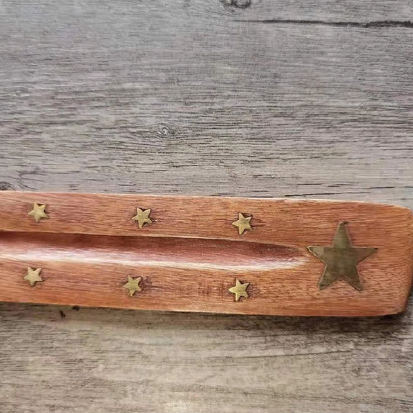 Close-up top view wooden incense burner with mixed gold star inlays central groove detail