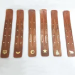Handcrafted wooden incense holder with gold star inlay flat lay top view Buddhist decoration