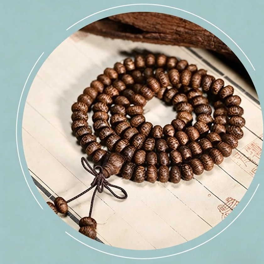 Neatly coiled wood bead prayer mala with knotted tassel pendant, circular frame display
