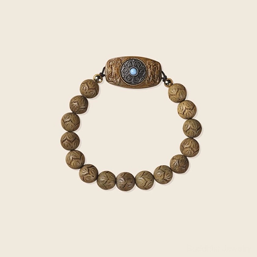 Simple engraved wooden prayer bracelet with turquoise central accent on light beige background