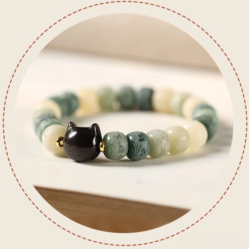 Yellow bodhi seed bracelet with black obsidian cat charm, overhead view showing vibrant bead colors and details