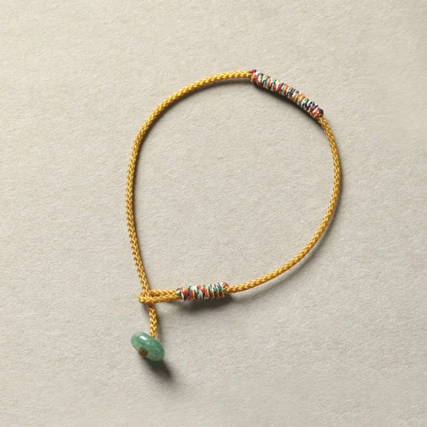 Yellow braided Buddhist bracelet with green aventurine bead and single woven trim section, mindfulness accessory