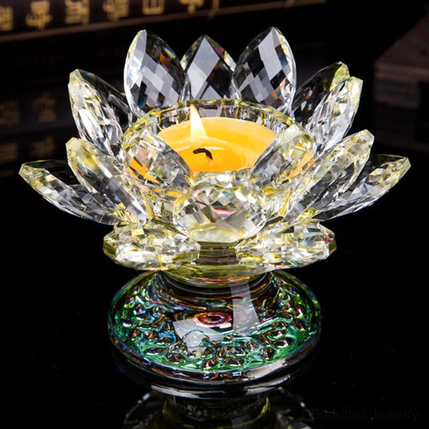 Yellow-toned citrine crystal lotus candleholder with iridescent base holding lit tea light candle