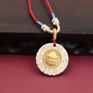 Yellow Jambhala wealth god pendant necklace with gold and white two-tone metal finish on red braided rope, front oblique view showing embossed deity motif