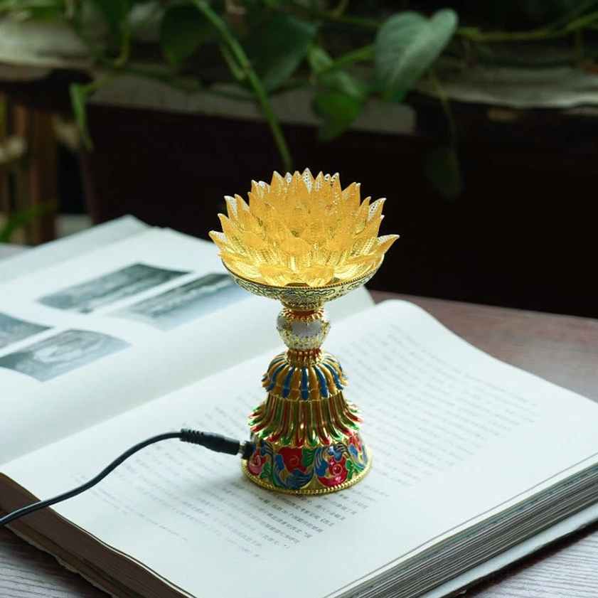 Yellow liuli glass lotus lamp with enamel decorated pedestal base on open book desk