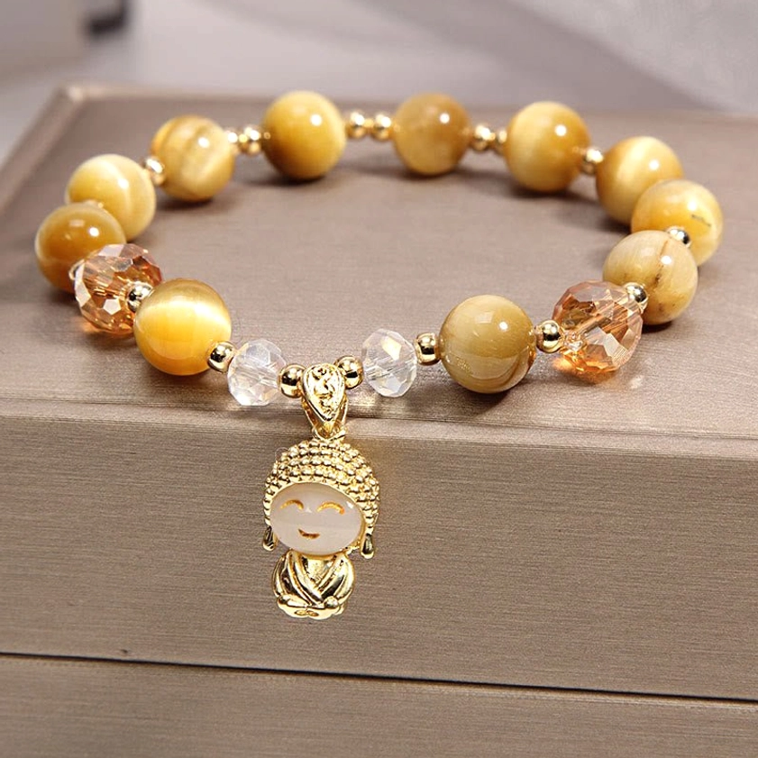 Yellow tiger eye meditation Buddha protection bracelet with gilded Buddha pendant on gray jewelry box