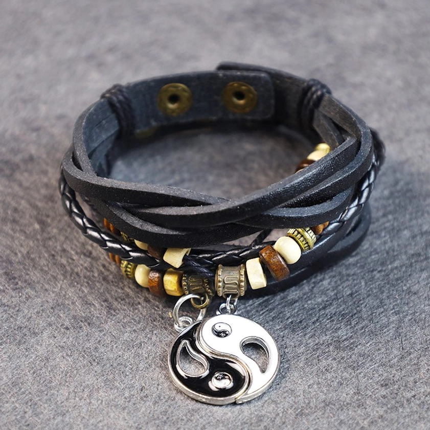 Yin yang harmony bracelet front view showing braided leather straps with beaded accents and round silver metal yin-yang charm