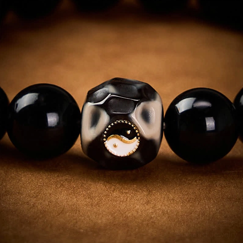 Handcrafted black onyx Yin Yang balance bracelet for protection, harmony and personal wellbeing on neutral background