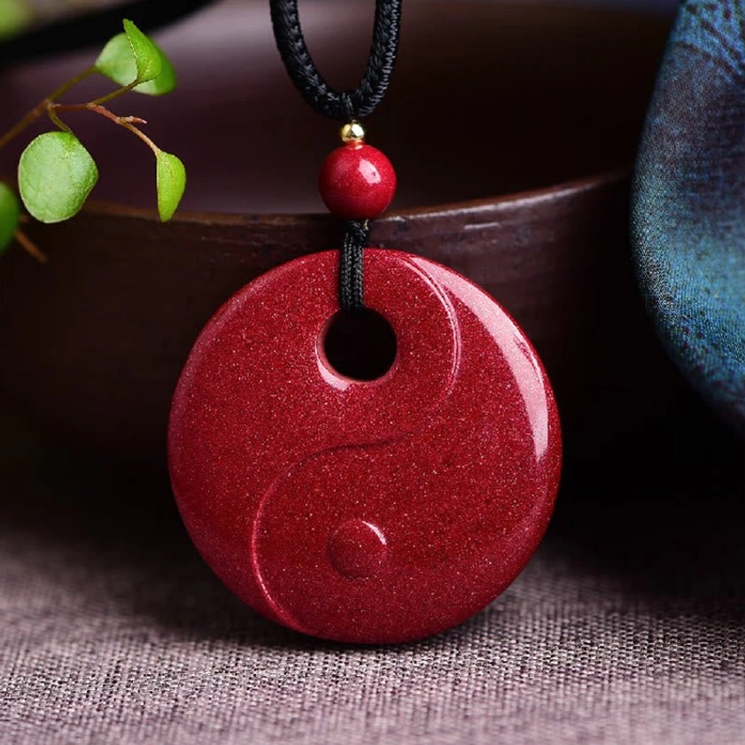 Yin Yang Tai Chi cinnabar Buddhist pendant with complete embossed balance symbol on round wine-red stone surface