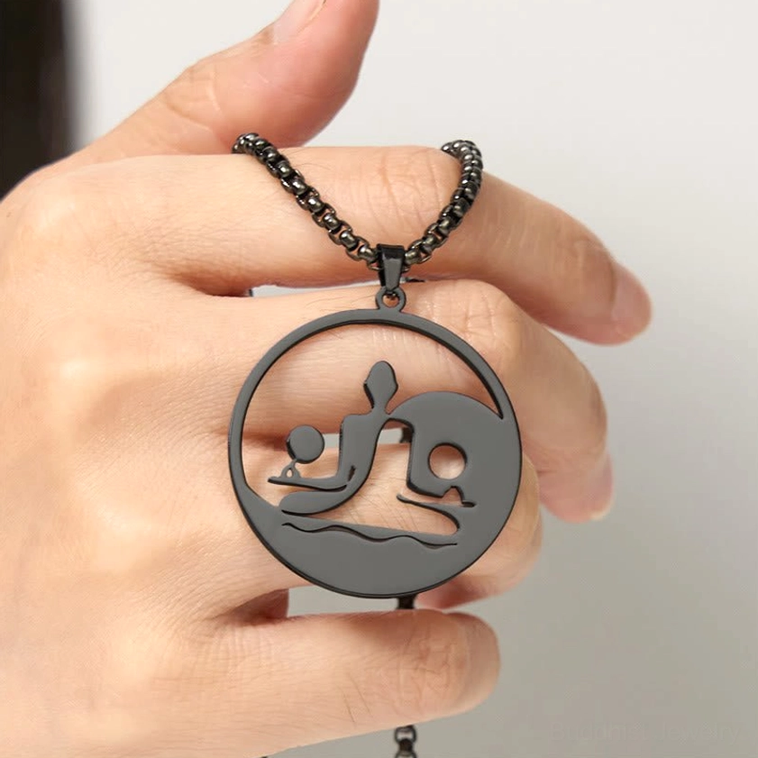 Yin yang buddha hollow pendant held in hand close-up detail stainless steel