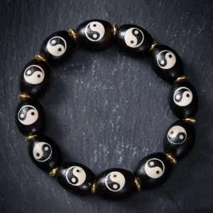Yin Yang agate dzi bead bracelet flat lay overhead view on grey background showing hand-painted yin yang patterns