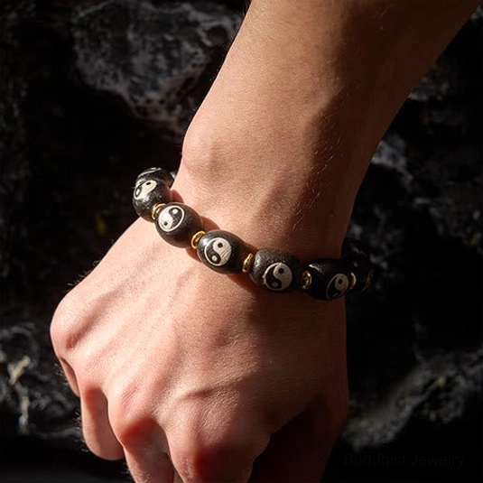 Yin yang dzi bead bracelet worn on left wrist showing how to wear buddhist protection bracelet daily