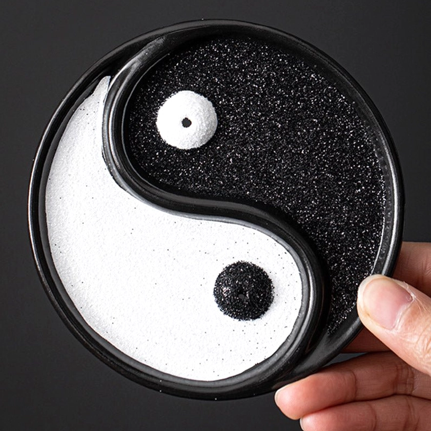 Yin Yang ceramic incense holder eye-level close-up view in hand showing detailed sand texture and glossy ceramic frame