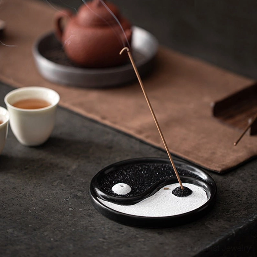 Yin Yang incense tray three-quarter side view with lit incense stick and Yixing teapot on tea table