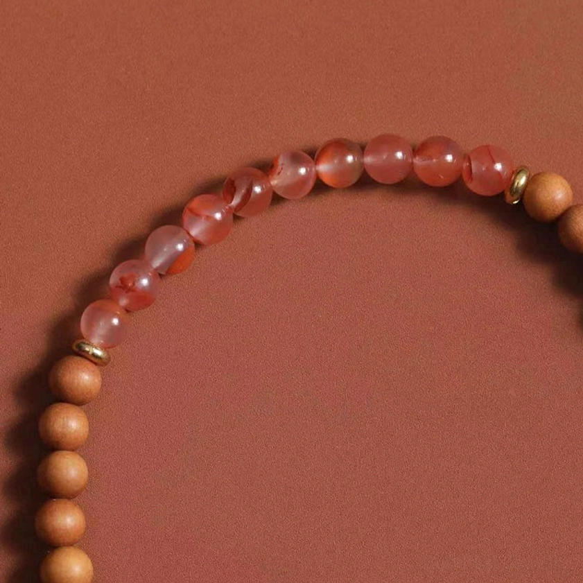 Zakiram fortune bracelet detail showing mixed sandalwood beads and glossy Red Agate round beads with metal connectors