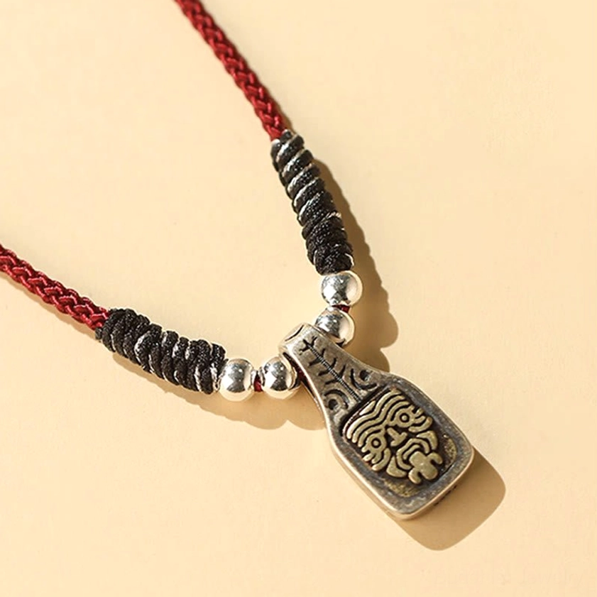 Zakiram goddess necklace side profile view with red cord black braided section and silver beads