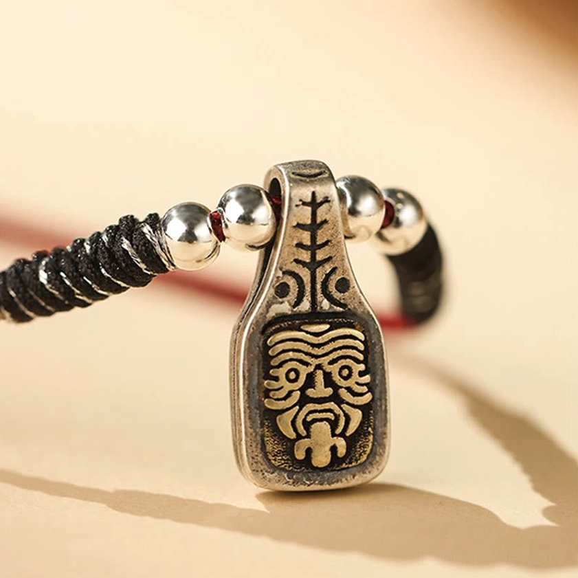 Sterling silver Zakiram pendant with engraved Buddhist deity face and black braided cord detail shot