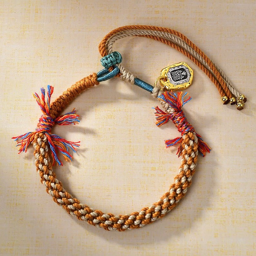 Buddhist Zakiram goddess bracelet with clear engraved metal charm, vibrant braided twine rope, and colorful spiritual tassel accents representing balance and prosperity