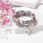 Zebra Jasper three-piece lotus enlightenment beaded bracelet set with silver charm on white surface