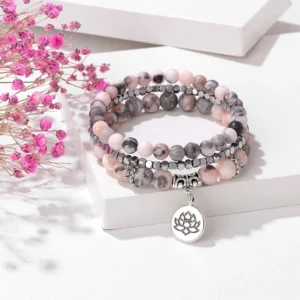 Zebra Jasper three-piece lotus enlightenment beaded bracelet set with silver charm on white surface