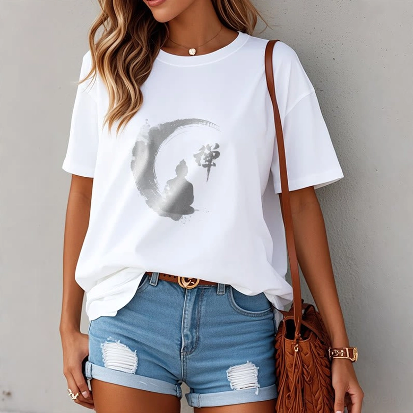 Female model wearing white Zen Buddha meditation t-shirt with denim shorts and crossbody bag, demonstrating how to style the Buddhist graphic tee for casual wear