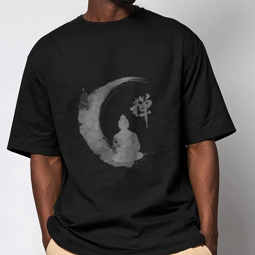 Male model wearing black Zen Buddha meditation t-shirt with khaki casual pants on plain indoor background, showing comfort and regular fit of Buddhist tee
