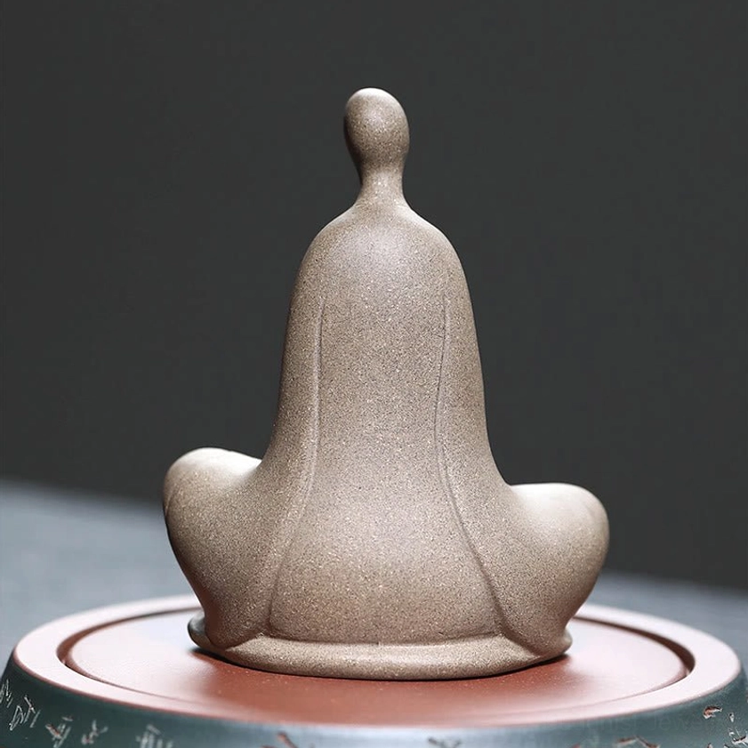 Zen Buddhist ceramic statue back view - rear silhouette showing robes and meditation pose