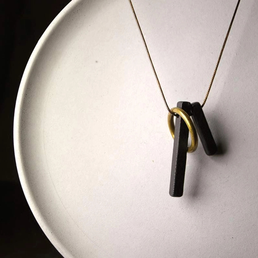 Zen circle Buddhist necklace full length display on white ceramic with golden chain