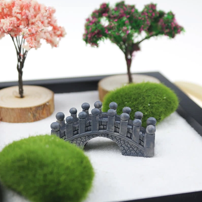 Close-up of zen garden with simulated trees, moss ball, and arched stone bridge detail