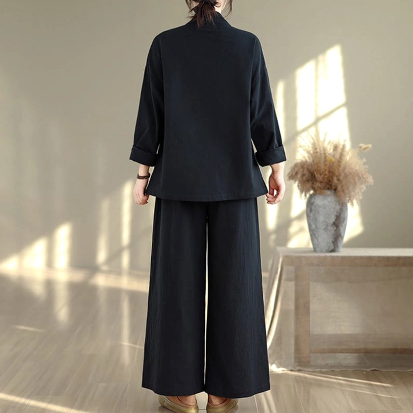 Three-quarter side view of woman wearing all-black zen meditation yoga uniform with relaxed fit and natural posture
