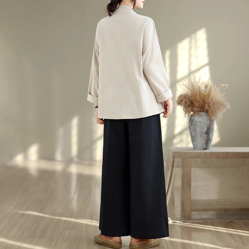 Women's zen meditation yoga uniform back view displaying plain beige top and black wide-leg pants from behind