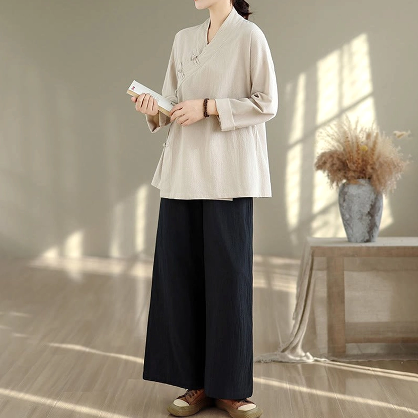 Zen meditation yoga set three-quarter side view of woman wearing beige top and black wide-leg pants with relaxed linen cotton fit