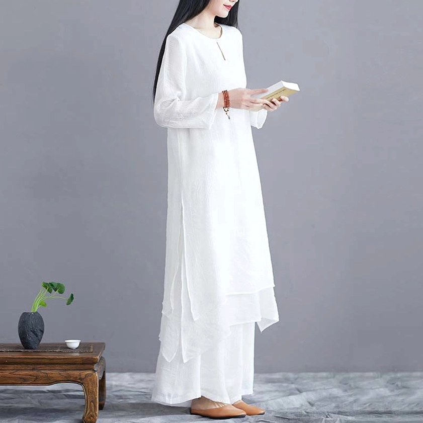 Side three-quarter view of white zen practice outfit featuring long sleeves and flowing wide-leg pants
