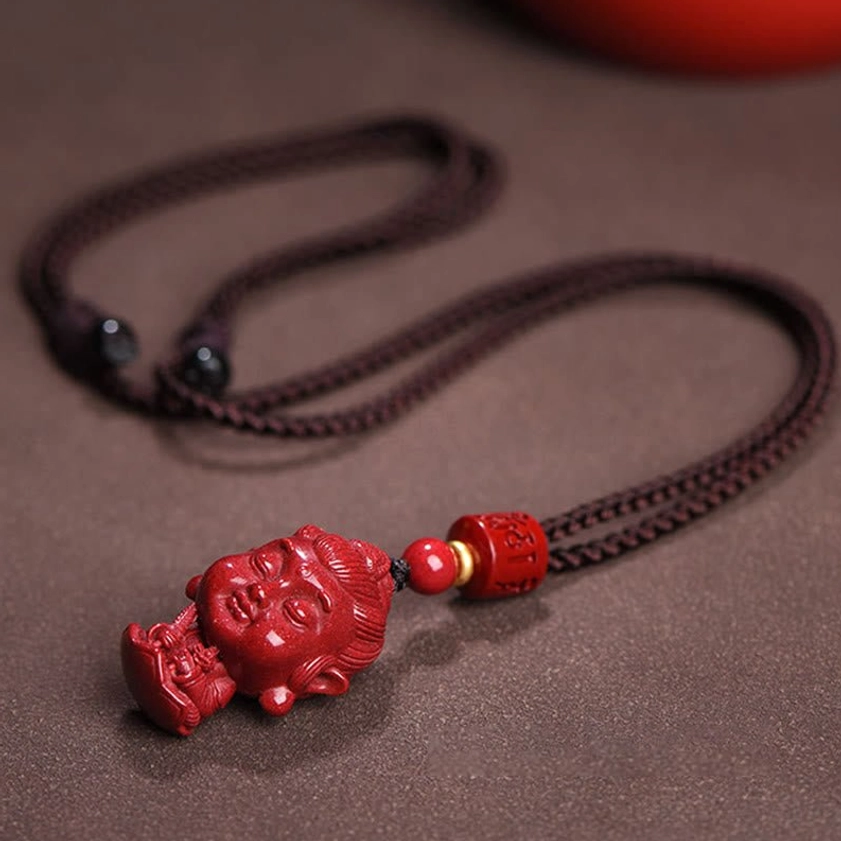 Zodiac natal Buddha cinnabar necklace flat lay with woven rope cord