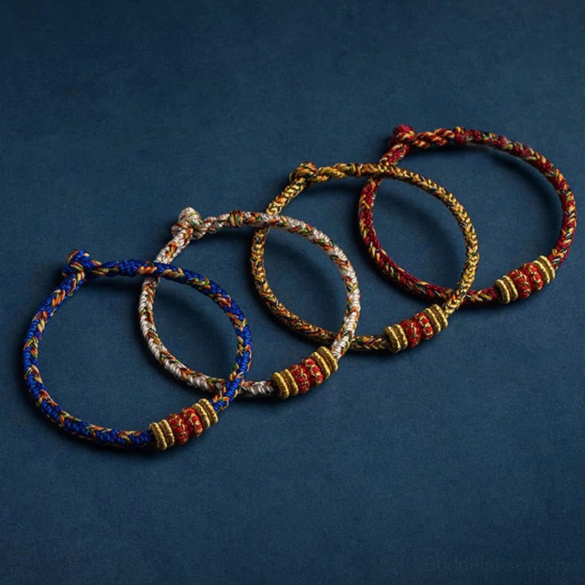 Assorted handcrafted buddhist natal buddha bracelets in multiple colors including blue, red and gold woven styles
