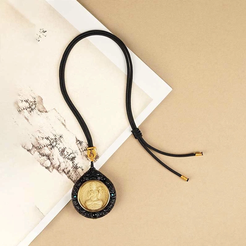 Buddhist necklace pendant showing braided cord and chain detail with attachment