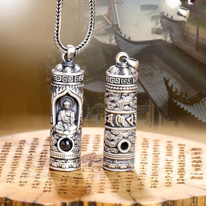 Guardian Buddha zodiac necklace pendant in hand showing compact size and embossed Buddhist iconography